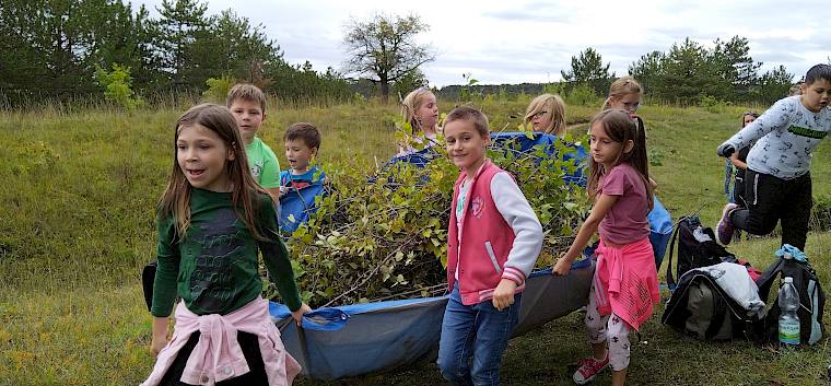 Wenn alle zusammenhelfen, können sogar die schwersten Planen getragen werden. © LPV/D.Lambropoulos Kinder mit Plane