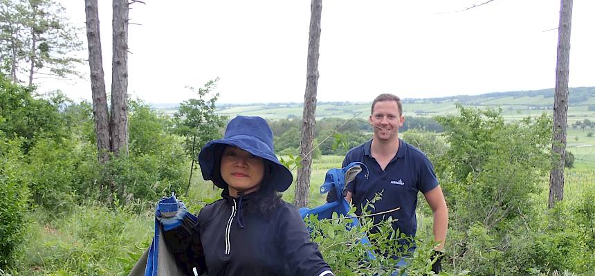 Volunteers tragen Plane mit Schnittgut