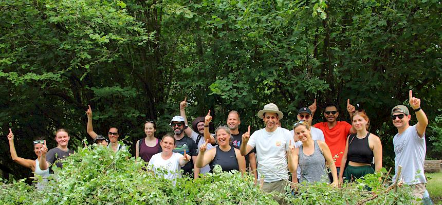 Volunteers hinter Schnittguthaufen