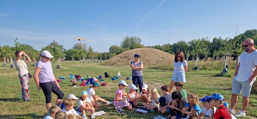 Kinder sitzen im Kreis in der Wiese