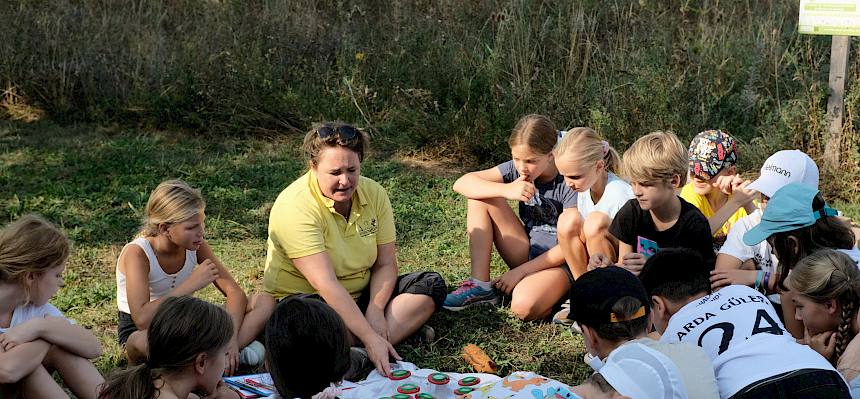 Kinder und Biologin sitzen im Kreis