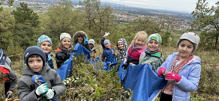 Kinder mit Schnittgut und Plane