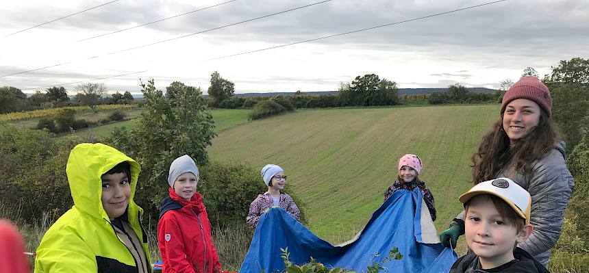 Schüler:innen tragen Plane