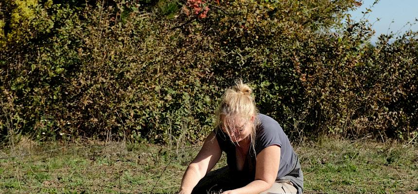 Frau sitzt am Boden uns sät an