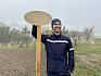 Benjamin Hofmann (Specialist E-I&A , Operations and Maintenance) hat vorab schon ein selbst designtes Holzschild angebracht, das auf den zukünftigen Wert der Blühflächen hinweist. © LPV/E. Weisz-Emesz Mann mit Holzschild