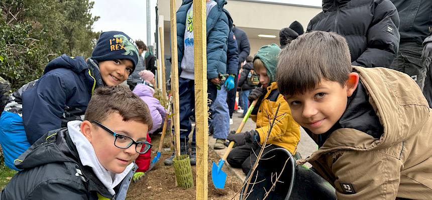 Kinder gießen einen Strauch