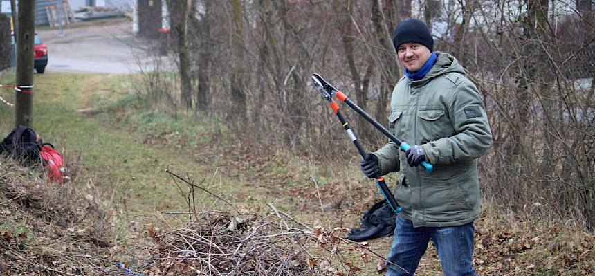 Mann mit Astschere und Schnittgut