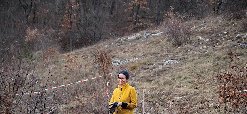 Lachende Frau steht am Trockenrasen