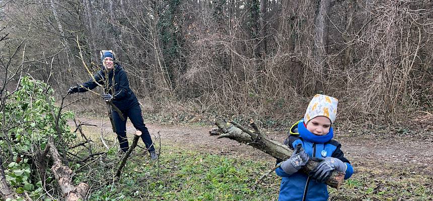 Kind trägt Holzstücke