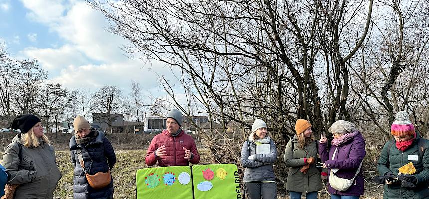 Menschen im Freien mit einer Infotafel