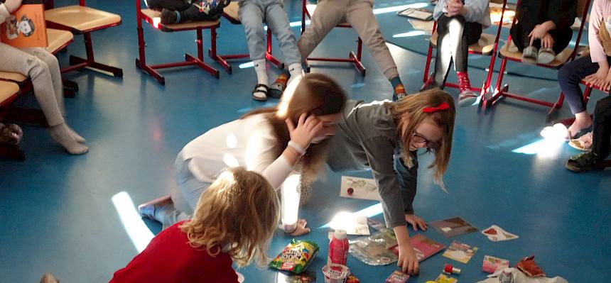Kinder sitzen am Boden und spielen