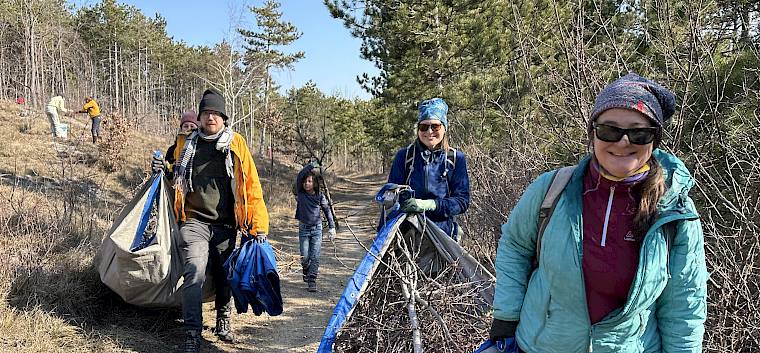 Mit Planen wurde das Schnittgut von der Fläche gebracht und für den Abtransport neben dem Weg deponiert. © LPV/E. Weisz-Emesz Menschen mit Planen und Schnittgut