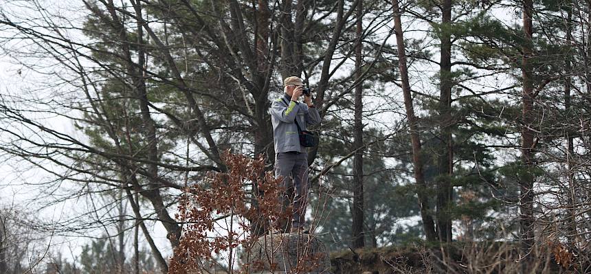Mensch steht auf Steinkegel und fotografiert
