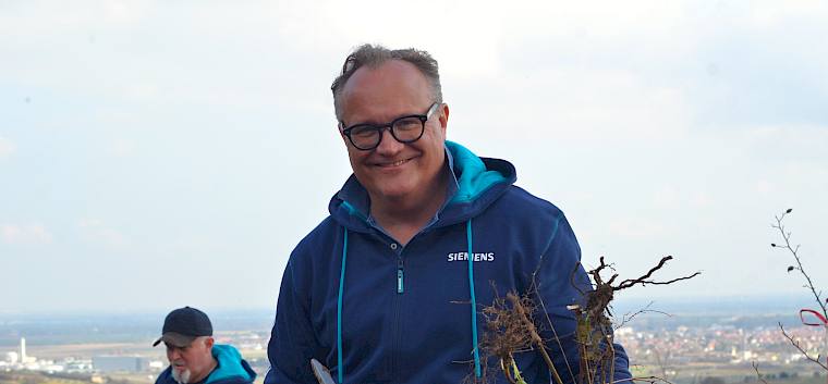 Sträucher, die samt Wurzeln ausgegraben werden, sind somit nachhaltig von den Trockenrasen.-Flächen entfernt. © LPV/F. Litzelmann Mann mit ausgegrabenen Strauch