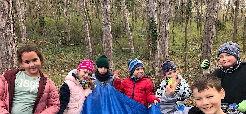 Kinder tragen Plane mit Schnittgut