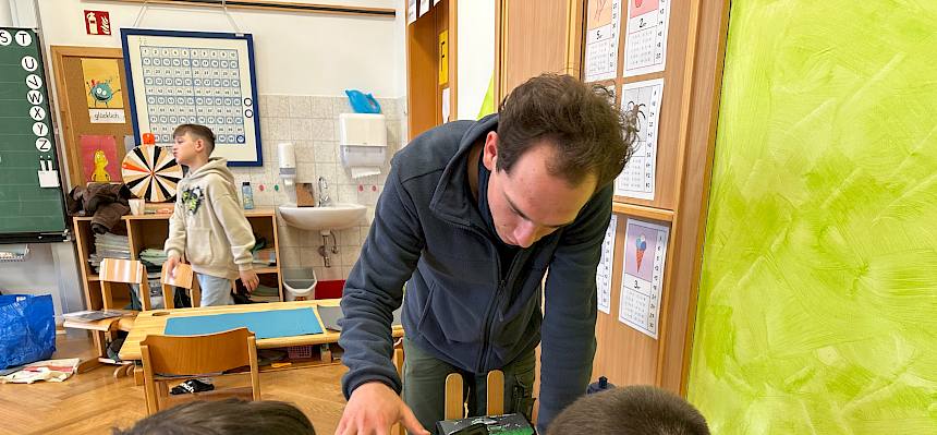 Mann arbeitet mit Kindern am Tablet