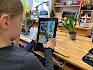 Anhand mitgebrachter Pflanzen konnte geübt werden, wie man mit dem Tablet ein gutes Foto für die Bestimmung macht. © LPV/E. Weisz-Emesz Kind fotografiert Blume mit Tablet
