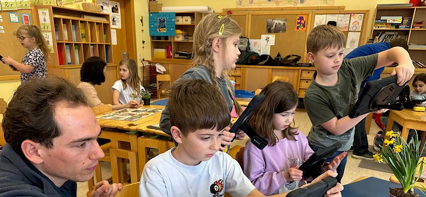 Mann arbeitet mit Kindern mit Tablet