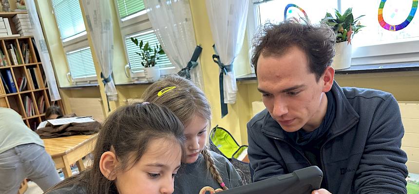 Mann arbeitet mit Kindern mit Tablet