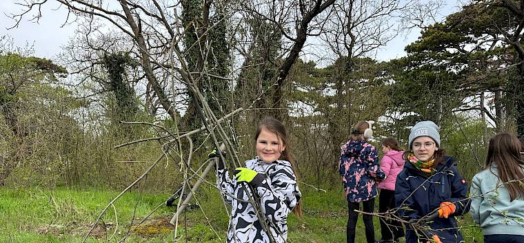 Die fleißigen Helfer:innen waren stolz auf die geleistete Arbeit. © LPV/E. Weisz-Emesz Kind trägt Äste