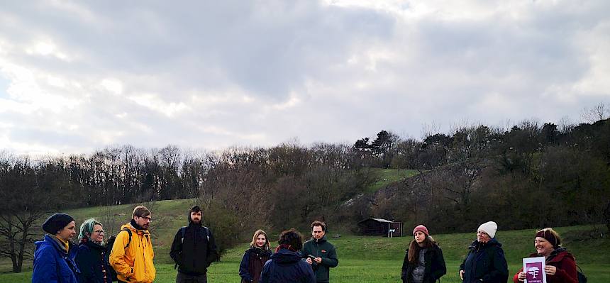 Menschen stehen im Kreis auf Wiese