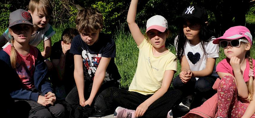 Kinder sitzen im Kreis