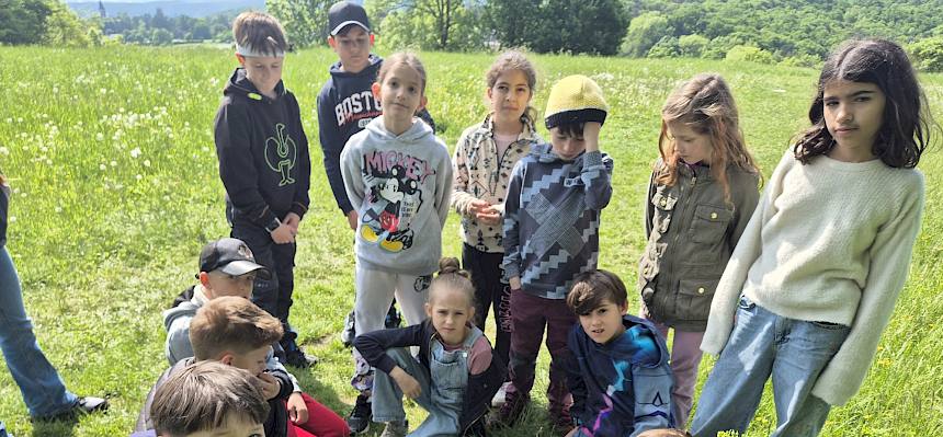 Kinder sitzen auf Wiese