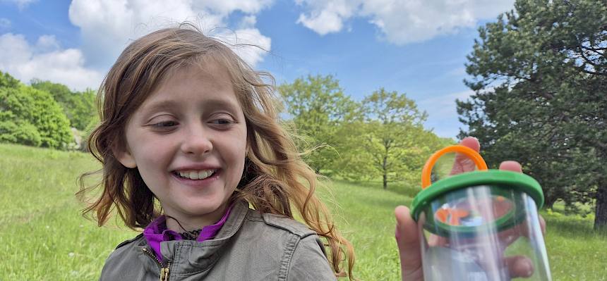 Kind mit Becherlupe