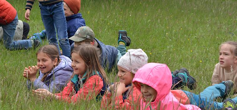 Beim Pantomime Spiel war voller Körpereinsatz gefragt. © LPV/F. Litzelmann Kinder liegen im Gras