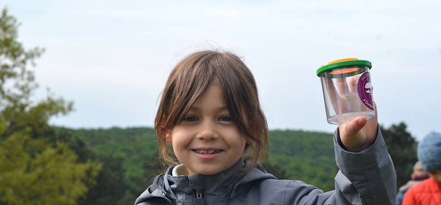 Kind mit Becherlupe