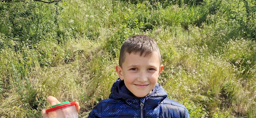 Schüler mit Becherlupe