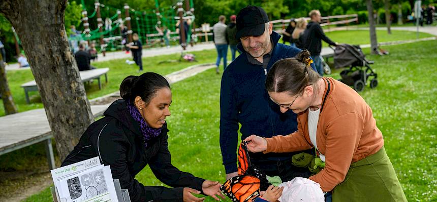 Menschen mit Stofftier bei Infostand