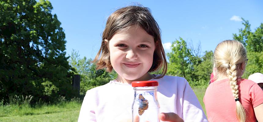 Kind mit Becherlupe und SChmetterling
