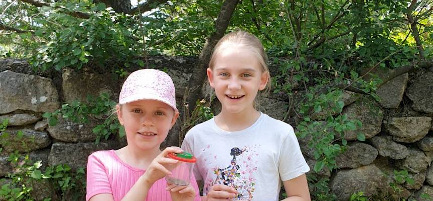 KInder mit Becherlupe