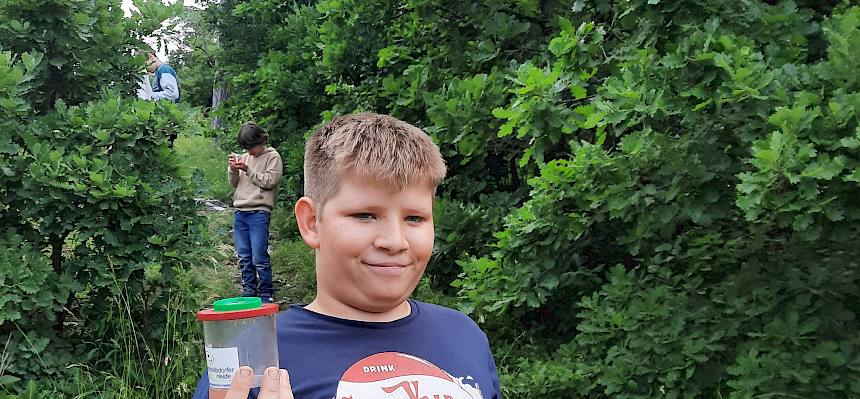 Kind mit Becherlupe