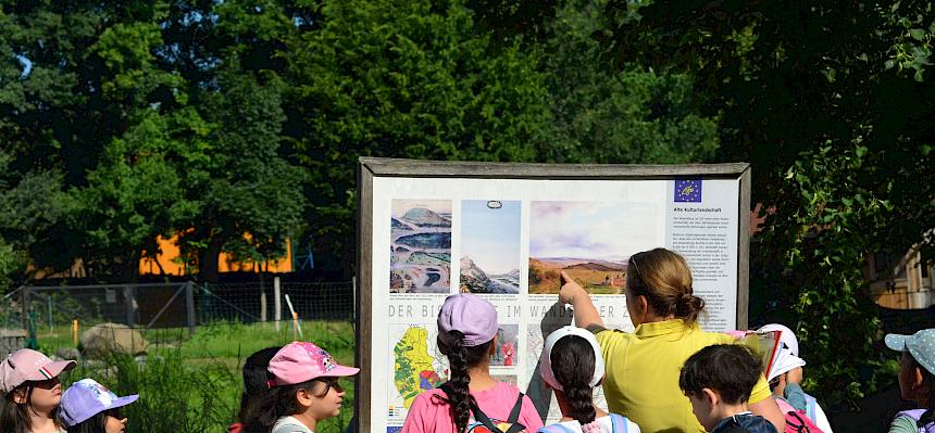 Naturpädagogin und Kinder vor Schautafel