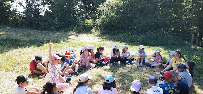 Kinder im Sitzkreis auf der Wiese