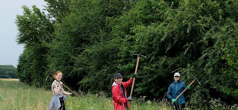 Heute kam bei der Entfernung der invasiven Goldruten auch der Krampen zum Einsatz. © LPV/J. FFischer Menschen mit Krampen