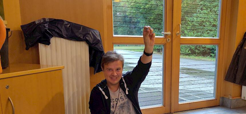 Mensch hält Miniatur-Haus