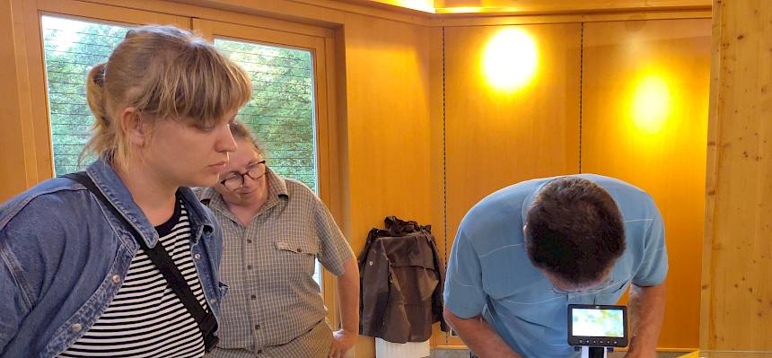 Person zeigt die Handhabung des Binokulars