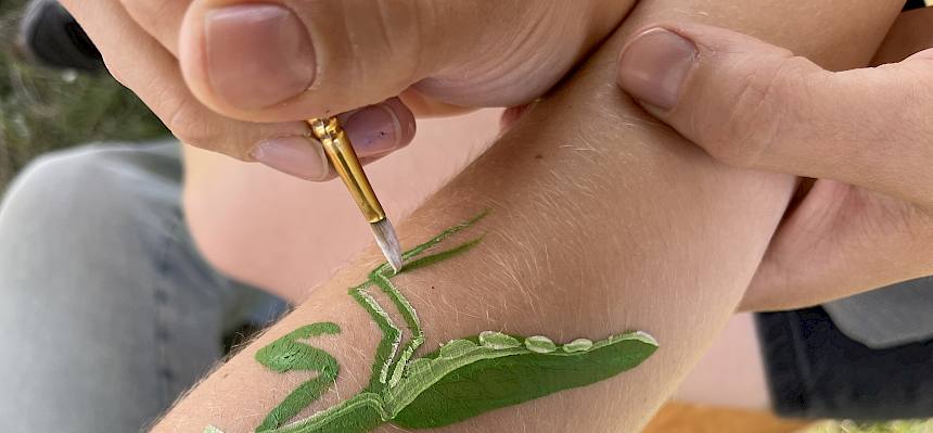 Gottesanbeterin wird auf Arm gemalt