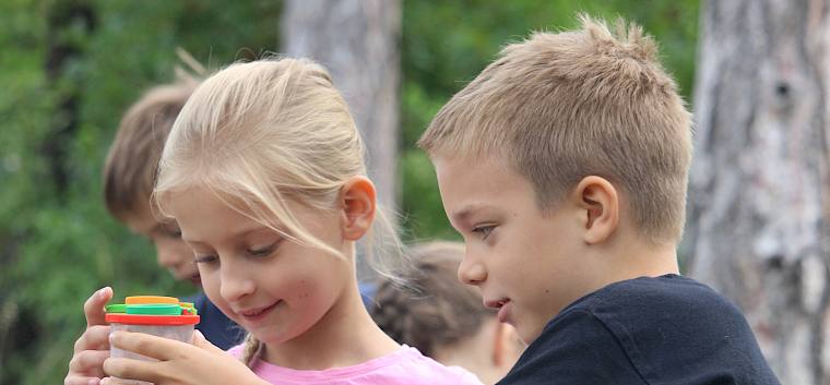 Um die Tierwelt der Trockenrasen im Kurpark Baden näher zu erforschen, machten sich die Kinder mit Becherlupen auf die Suche nach Insekten und Spinnen. © LPV/F. Hohn Schüler.innen schauen in Becherlupe