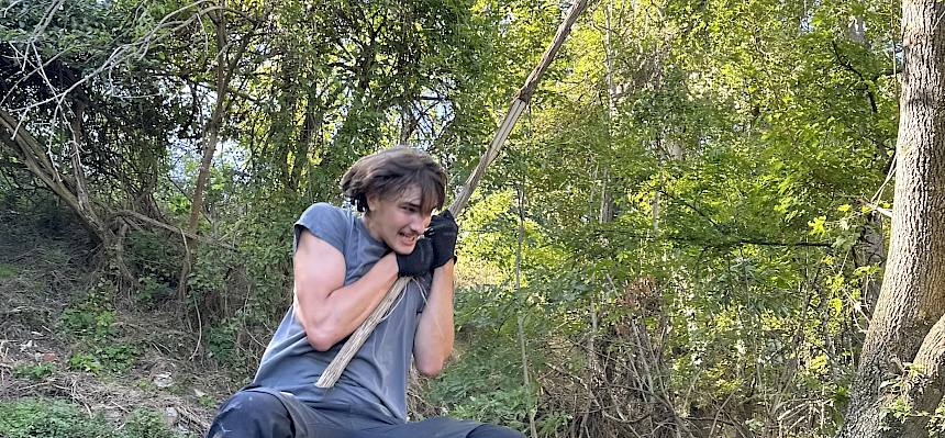 Mann schwingt auf Liane