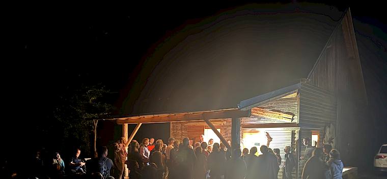 Das Mödlinger Waldklassenzimmer war heute Schauplatz der Langen Nacht der Naturparke. © Christian Weisz Menschen im Dunkeln bei einer beleuchteten Hütte