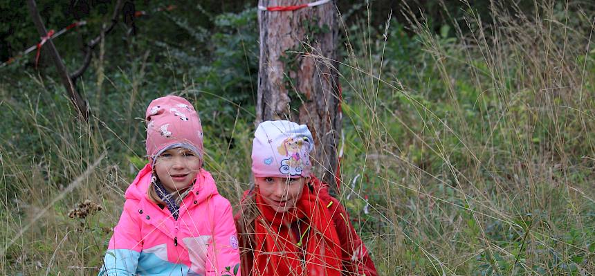 Kinder verstecken sich im Gras des Trockenrasens