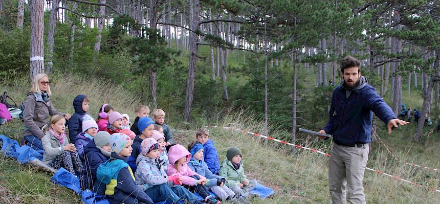 Mann erklärt Kindern etwas