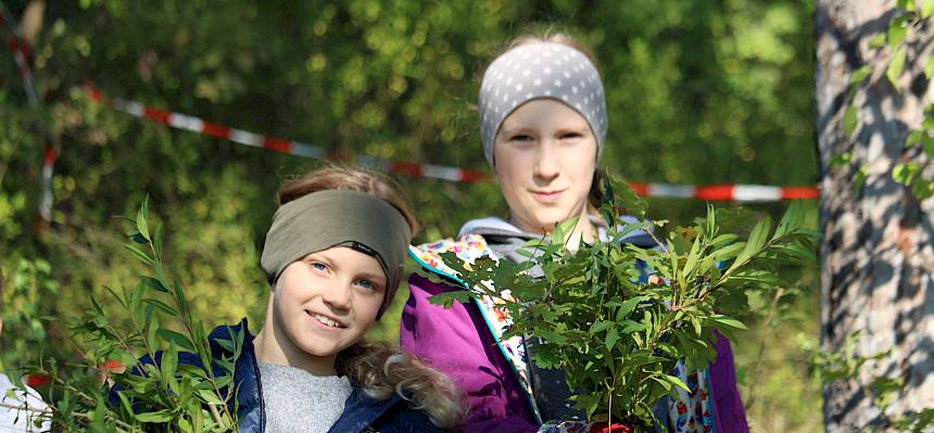 Kinder präsentieren abgeschnittenes Gehölz