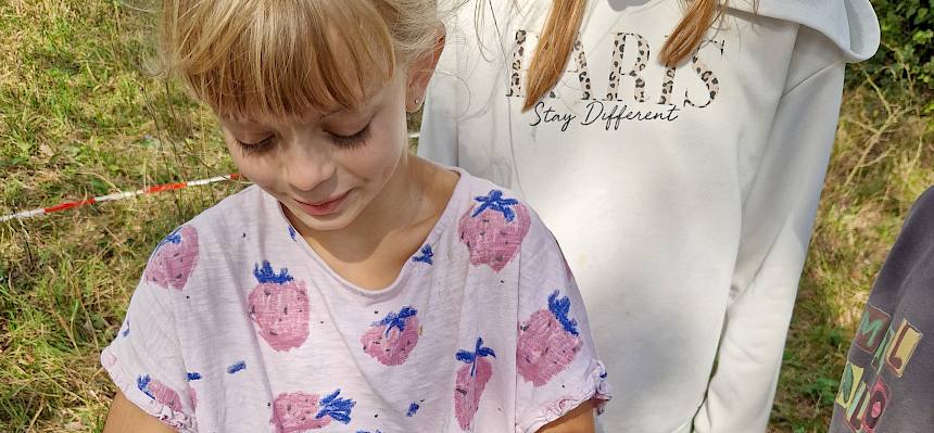 Kind mit Steppen-Sattelheuschrecke