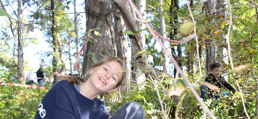 Jugendliche sägt ein Gehölz