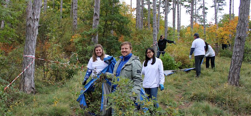 Menschen tragen Plane mit Schnittgut